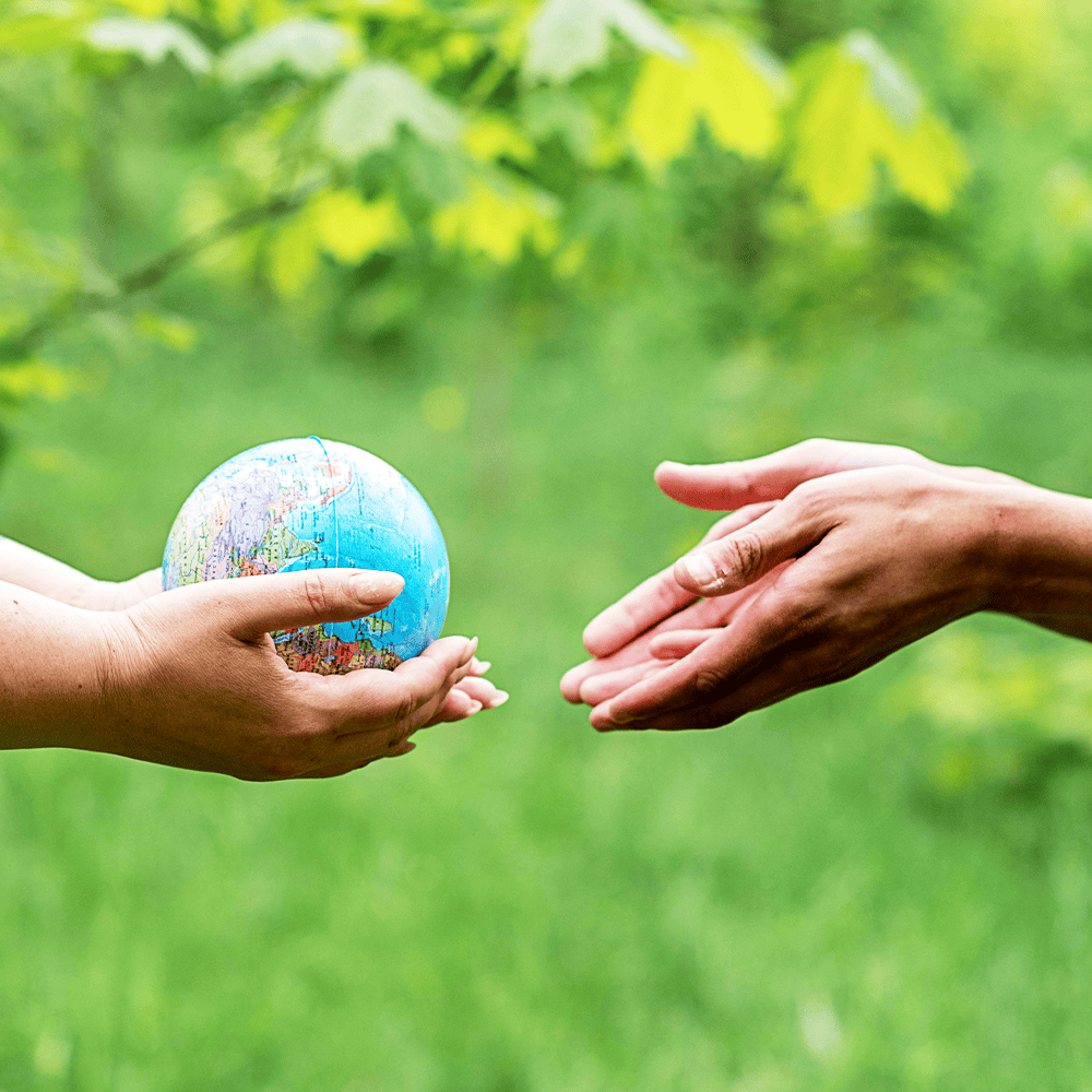 two people handing over the globe to one another