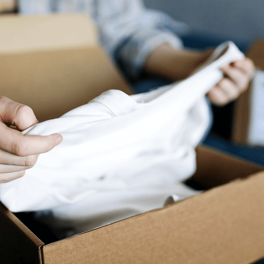Person opening up box containing a white shirt
